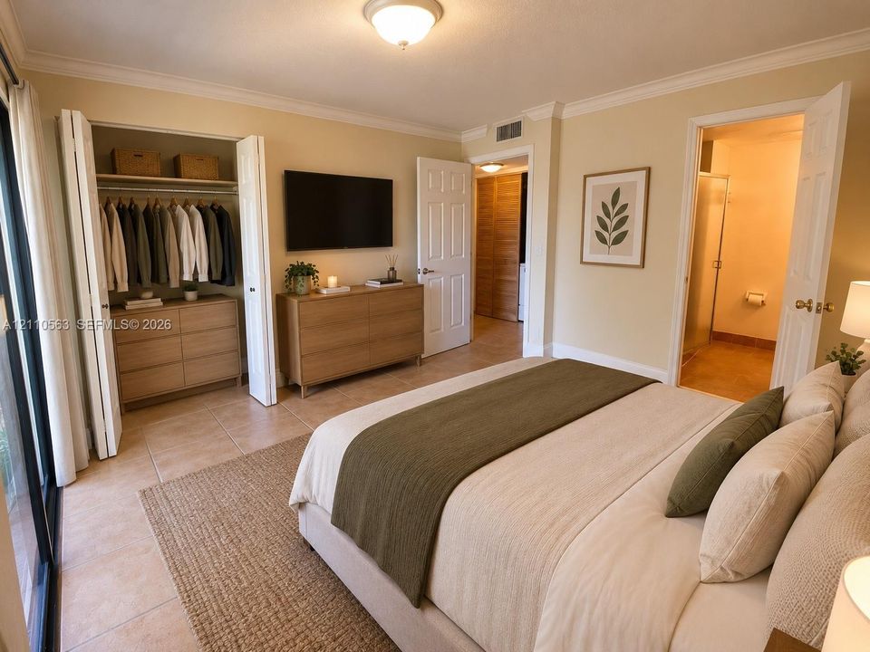 Bedroom featuring tile flooring, crown molding, two-panel interior doors, and a built-in reach-in closet with folding doors