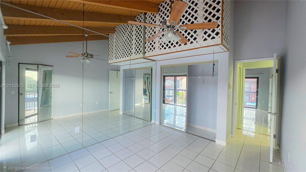 Vaulted ceilings with exposed timber beams, ceramic tile flooring, mirrored wall panels, overhead ceiling fans, and latticework detailing