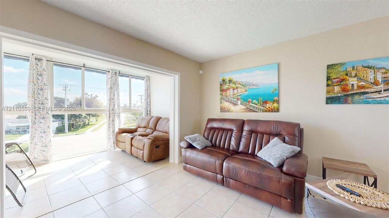 Large-format windows, white ceramic tile flooring, and neutral wall tones
