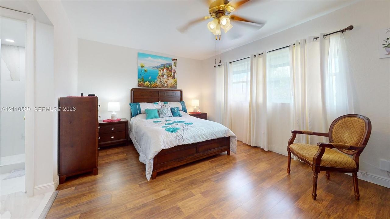 Wood-finish flooring, multi-pane windows with hardware, and an attached ceiling fan with light fixture