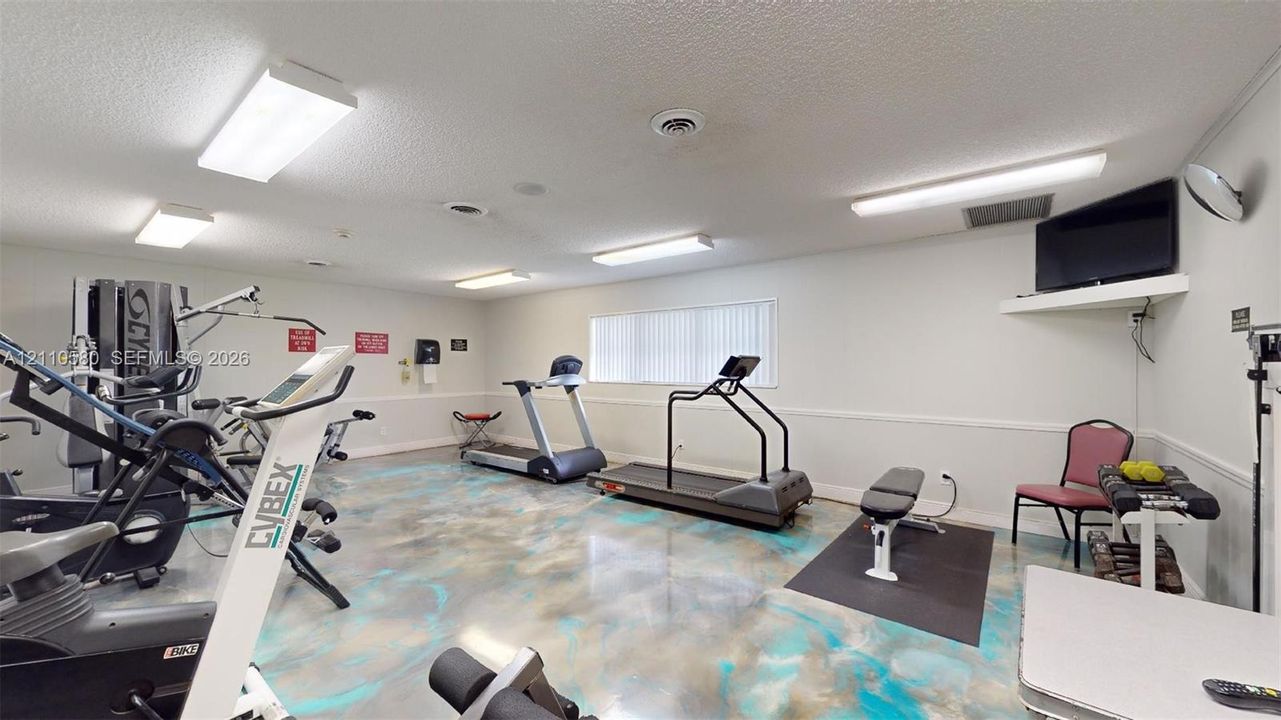 Interior space featuring high-gloss decorative epoxy flooring and multiple overhead fluorescent light fixtures