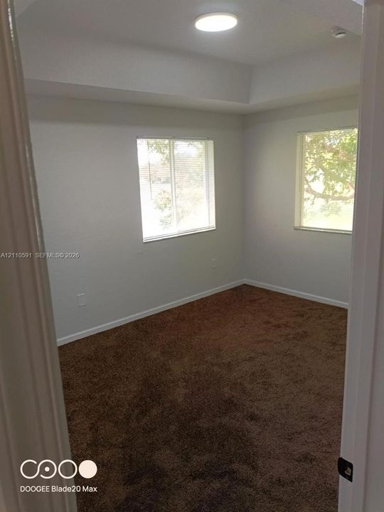 Interior space featuring wall-to-wall carpeting, dual windows, and a recessed ceiling design with a flush-mount light fixture