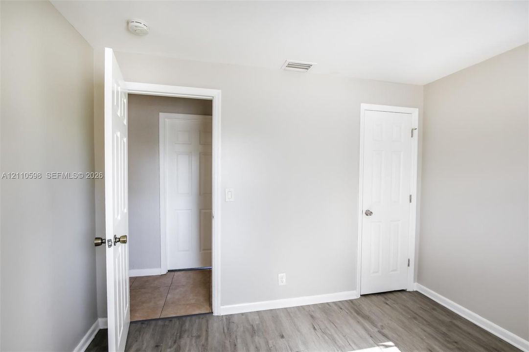 Neutral-toned interior featuring wood-finish flooring, interior panel doors, and neutral wall paint