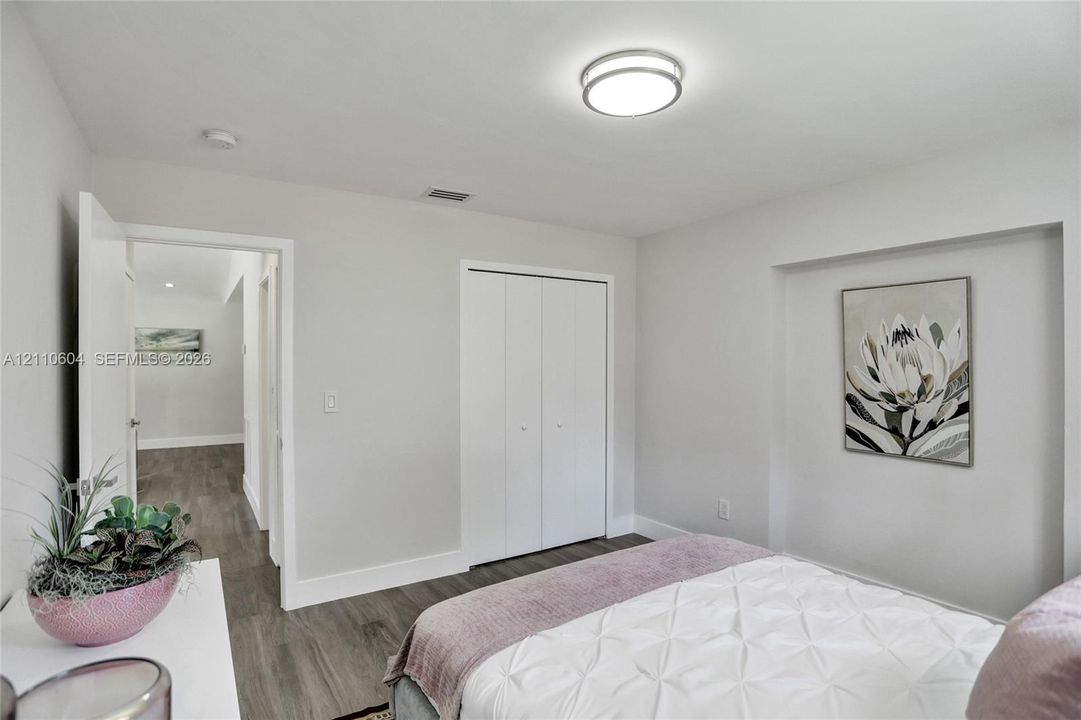 Neutral-toned interior featuring wood-finish flooring, a wall-recessed alcove, and a bi-fold closet
