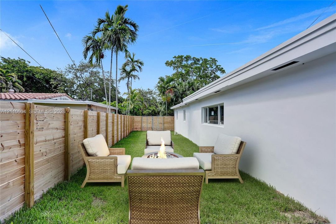 Private side yard featuring a manicured lawn and a tall wood-panel fence