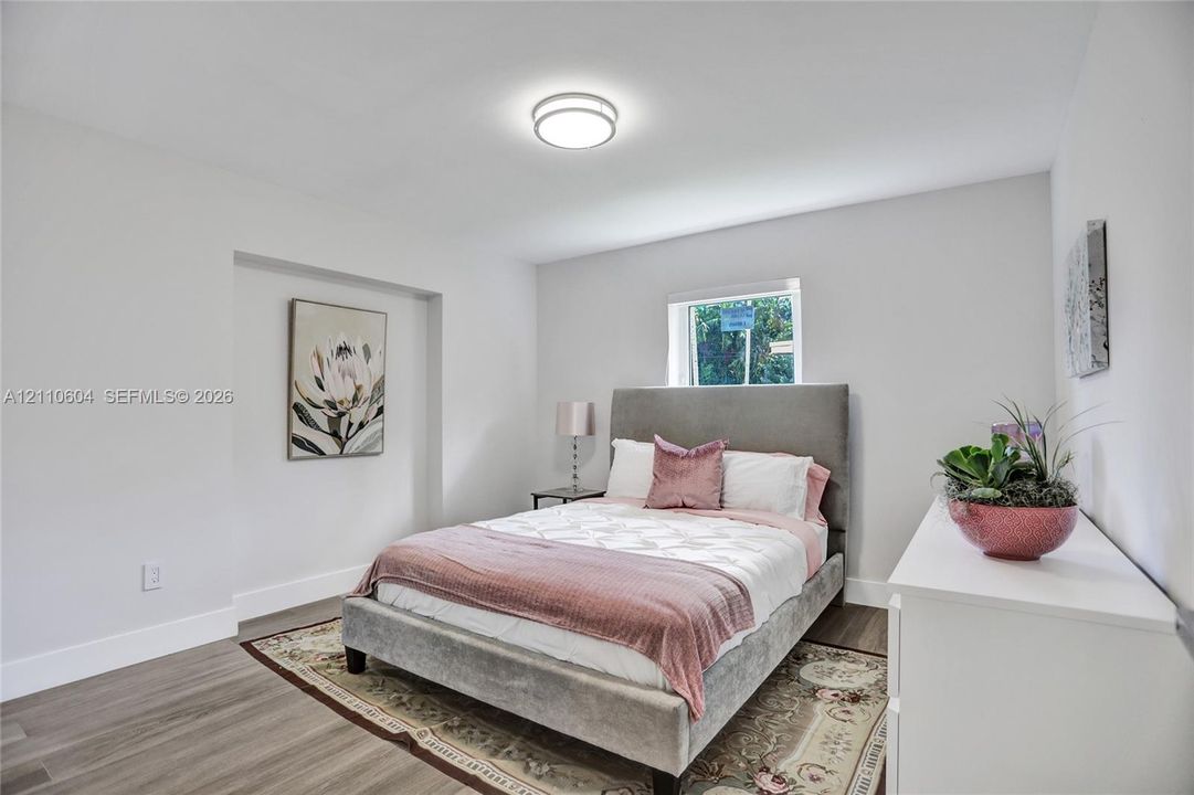 Neutral interior featuring wood-finish flooring, recessed wall niche, and flush-mount ceiling lighting