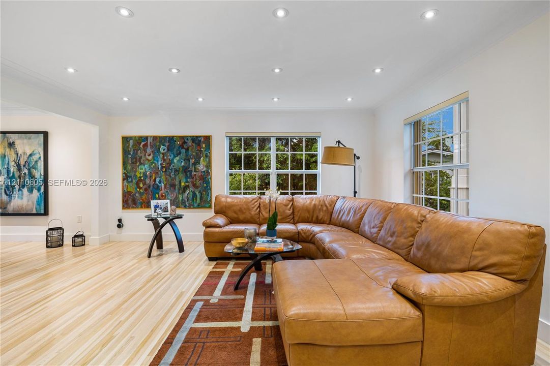 Light-toned wood-finish flooring, recessed lighting, and grid-pattern windows
