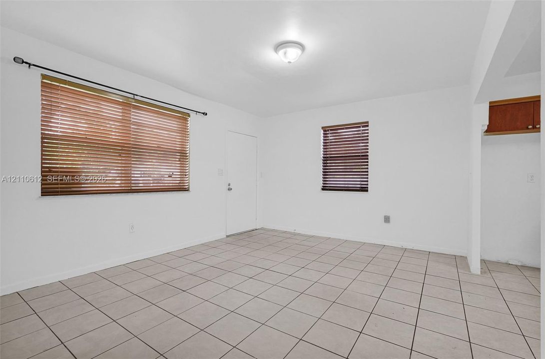 Tile flooring, neutral wall finishes, horizontal slat window blinds, and overhead lighting