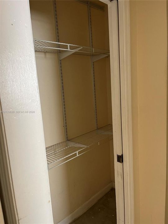 Storage closet featuring adjustable metal wire shelving and wall-mounted support tracks