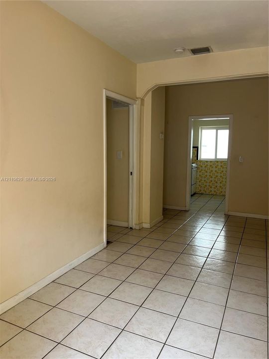 Ceramic tile flooring, arched entryways, and natural light from a double-pane window