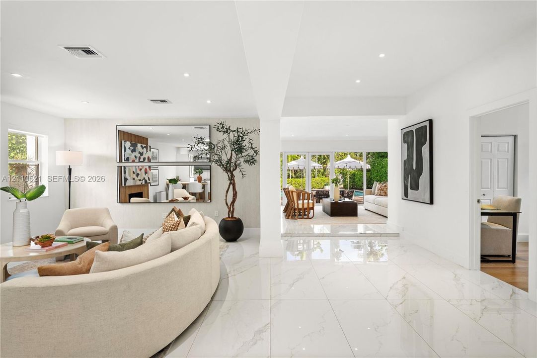 Large-format polished stone flooring, recessed lighting, and wall-to-wall glass sliding doors