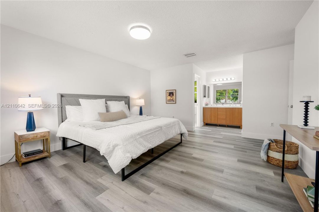 Neutral-toned wood-finish flooring and integrated vanity with wooden cabinetry