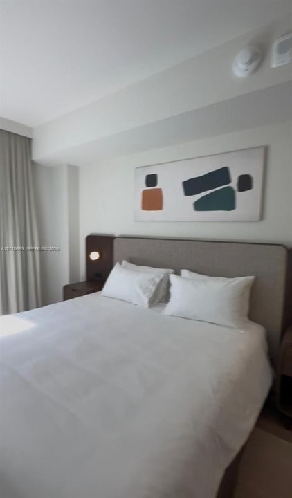 Custom upholstered headboard with integrated bedside shelving and circular wall-mounted lighting