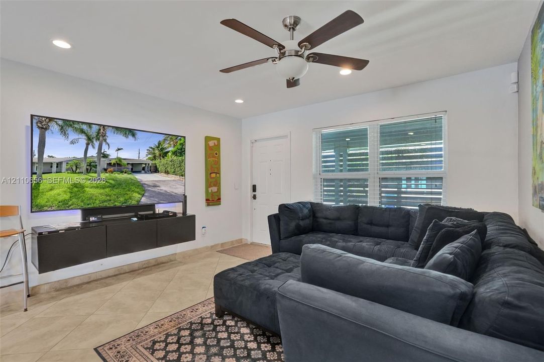 Ceramic tile flooring, recessed lighting, ceiling fan with light fixture, and wall-mounted storage cabinetry