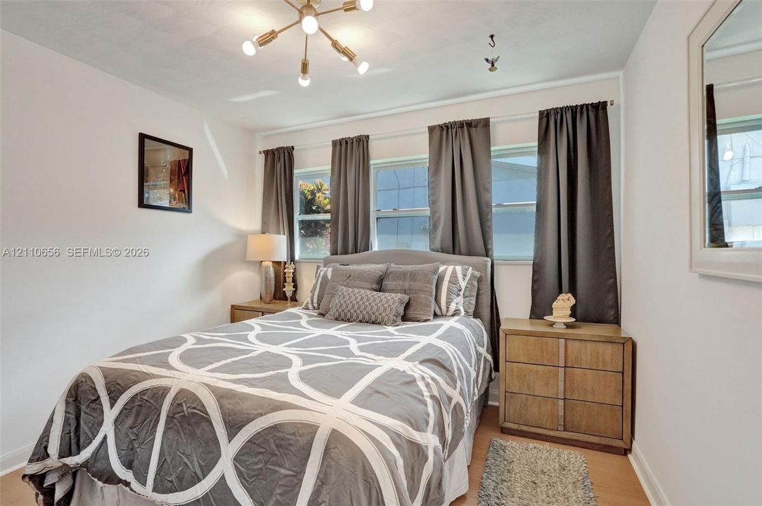 Multi-pane windows, wood-finish flooring, and a modern six-light sputnik-style chandelier