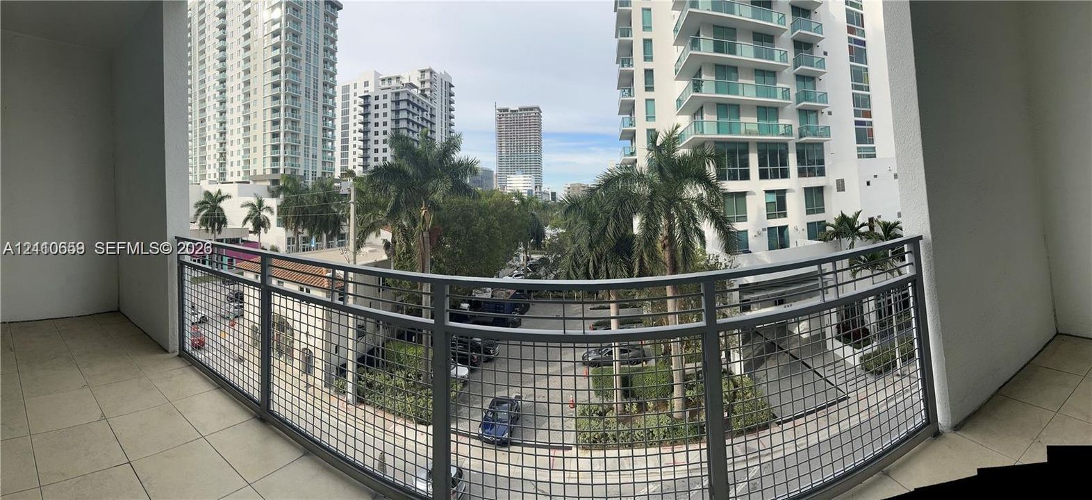 Covered balcony featuring tile flooring and a metal mesh railing