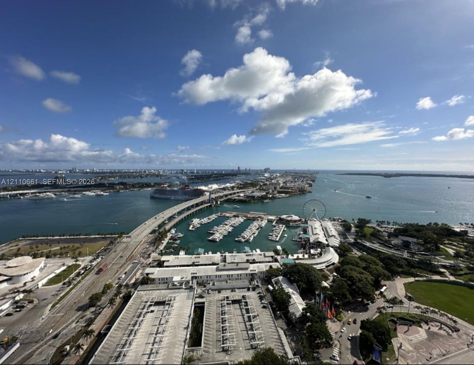 Aerial perspective showcasing a coastal cityscape with deep-water channels, marina slips, major bridge infrastructure, and expansive waterfront access