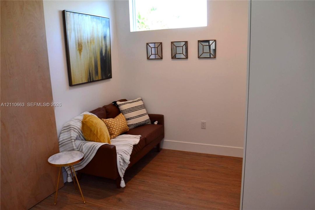 Wood-finish flooring, high-set horizontal window, and smooth-finish interior walls