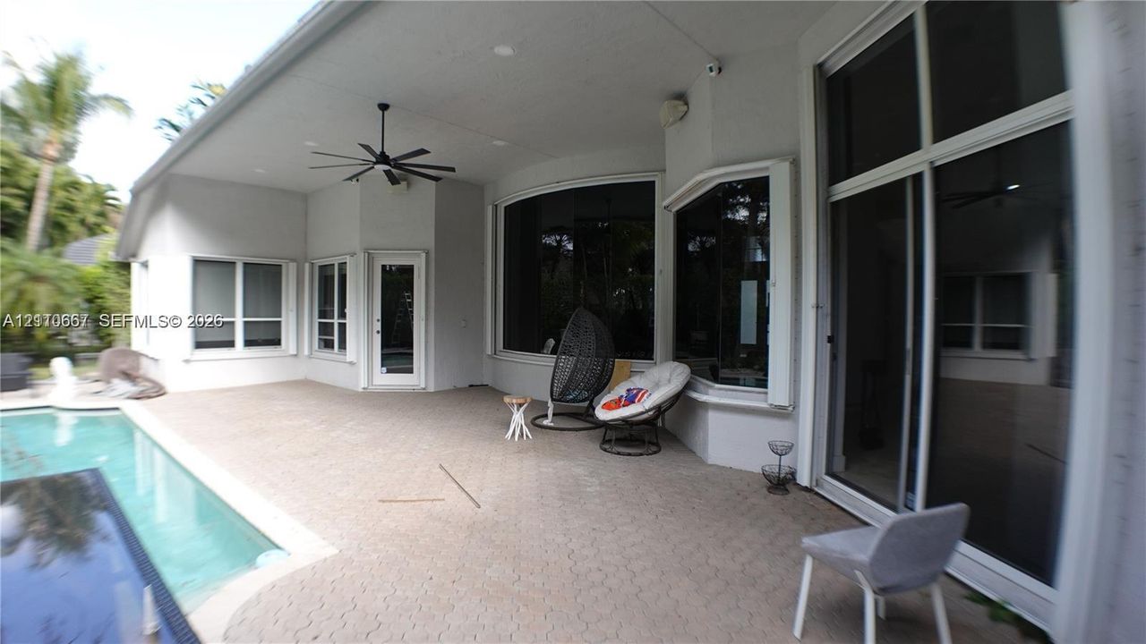 Covered patio featuring a paver deck, recessed lighting, ceiling fan, and access to an in-ground pool