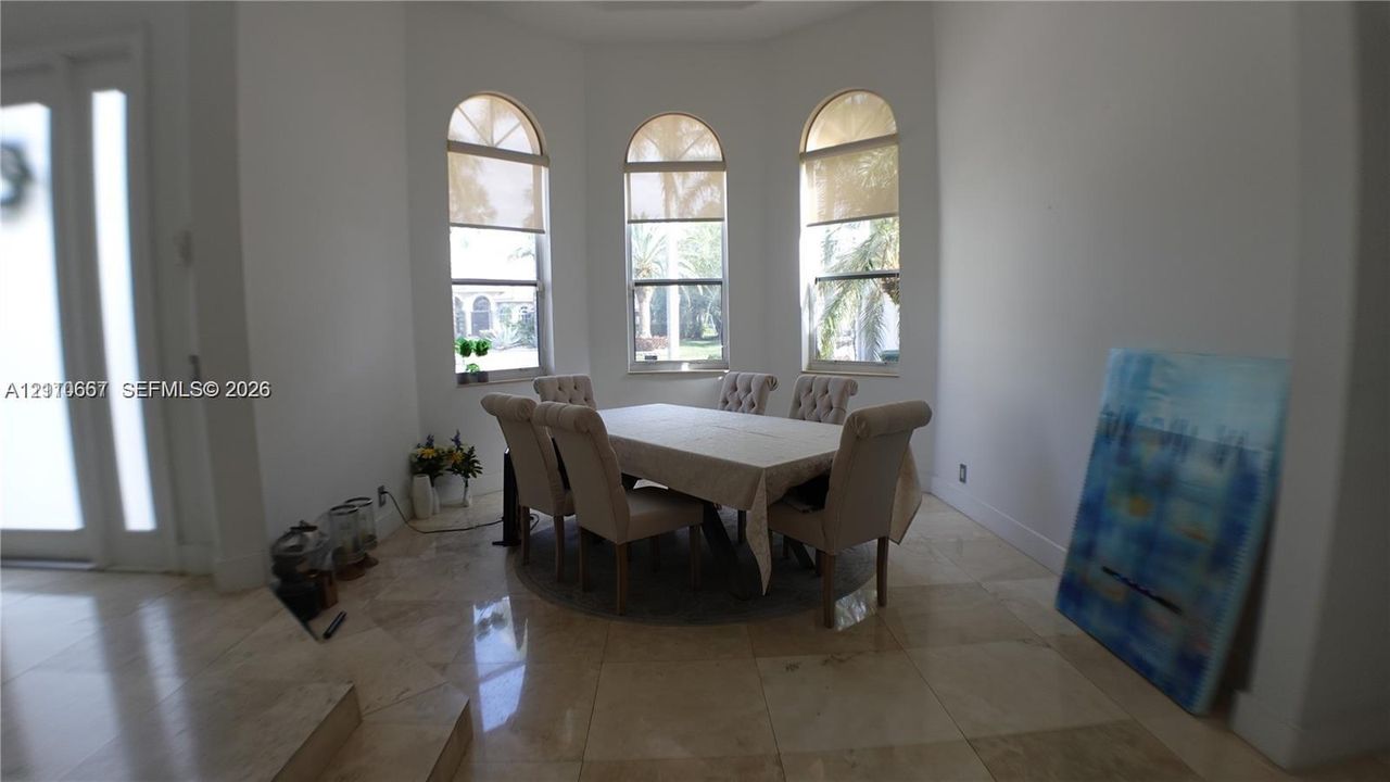 Arched windows, bay window configuration, and polished stone tile flooring