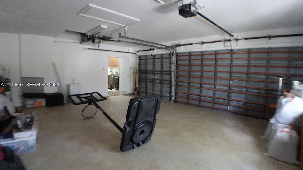 Attached multi-car garage featuring automated door openers and integrated wall-mounted storage shelving