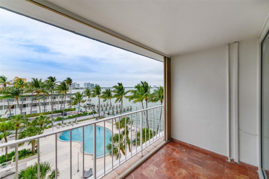 Private balcony featuring stone-finish flooring and a white metal railing