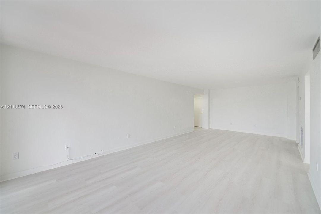 Expansive interior featuring light-toned wood-finish flooring and neutral-painted walls