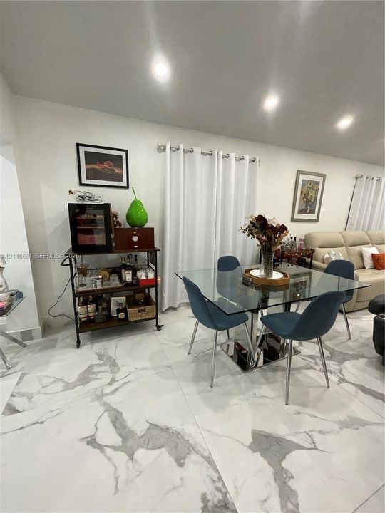 Large-format white tile flooring with grey veining, neutral wall paint, and recessed ceiling lighting