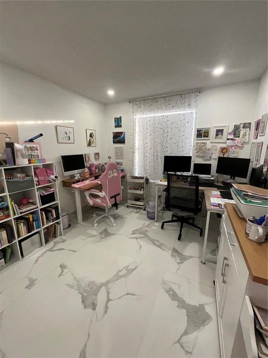 Large-format tile flooring featuring high-contrast veining, built-in open-shelf cabinetry, and recessed lighting