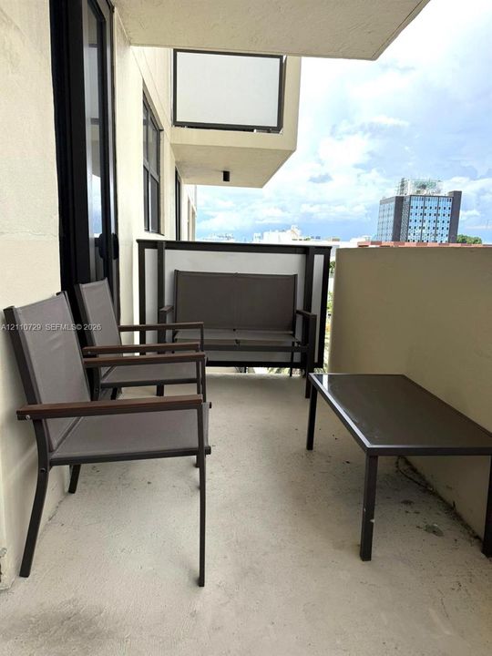 Covered balcony featuring concrete flooring and a privacy partition