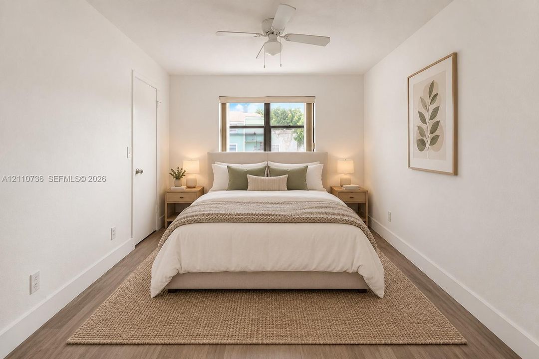 Interior space featuring wood-finish flooring, a neutral color palette, a central ceiling fan, and a single-pane window