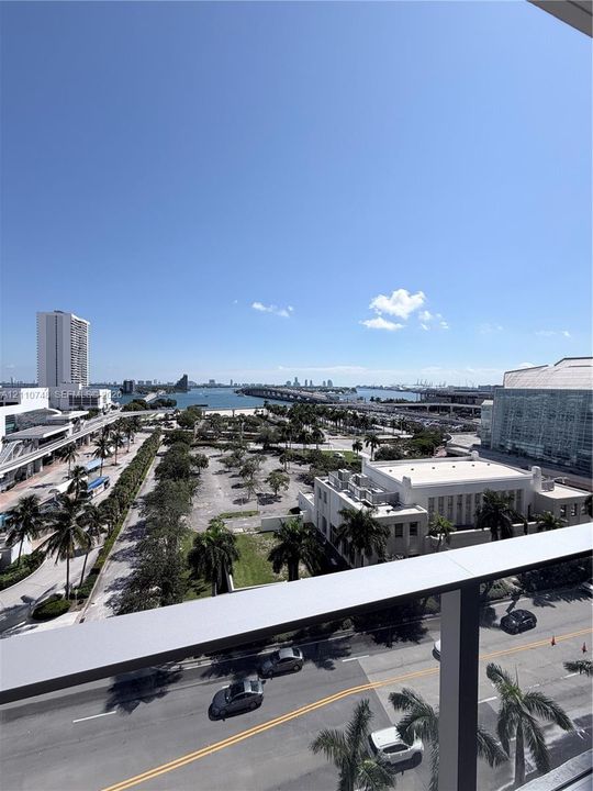 Elevated terrace featuring a metal railing with a wide-angle perspective of the surrounding cityscape, waterfront, and bridge