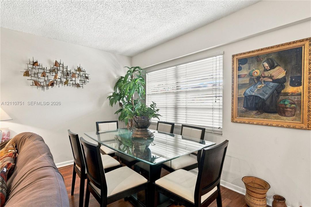 Multi-purpose room featuring wood-finish flooring and large horizontal blinds