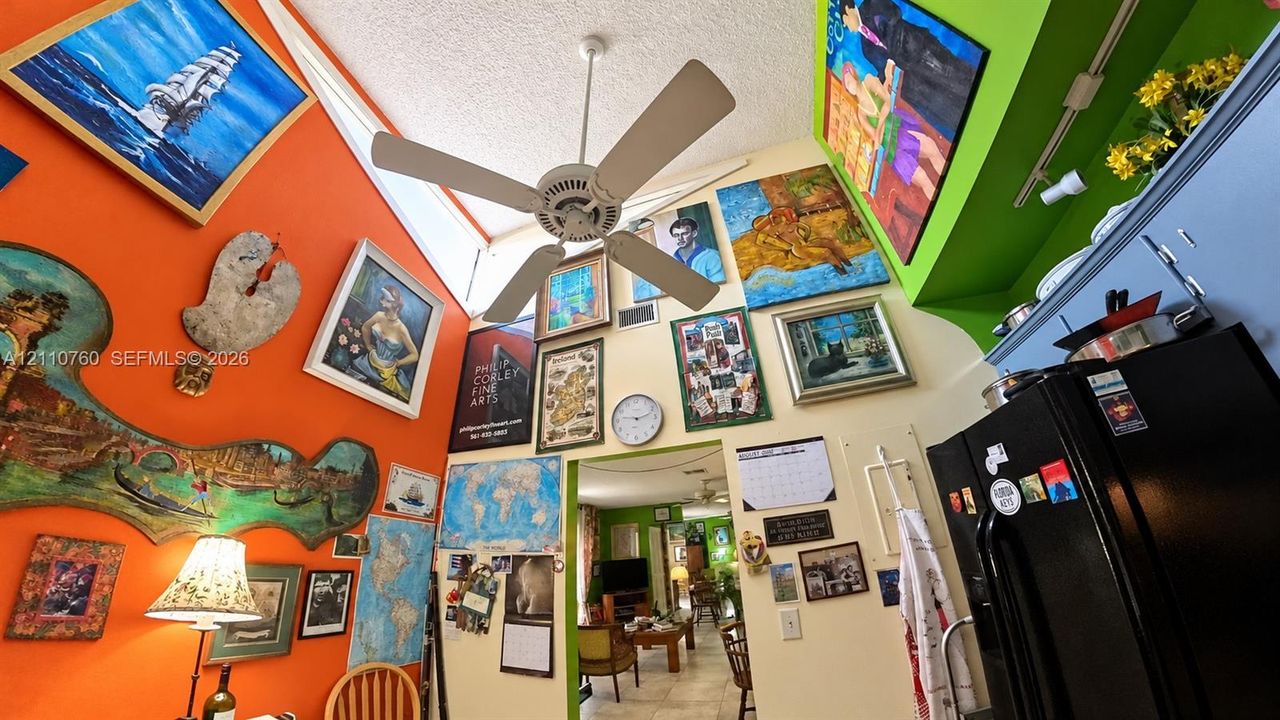 Vaulted ceilings featuring a central white ceiling fan