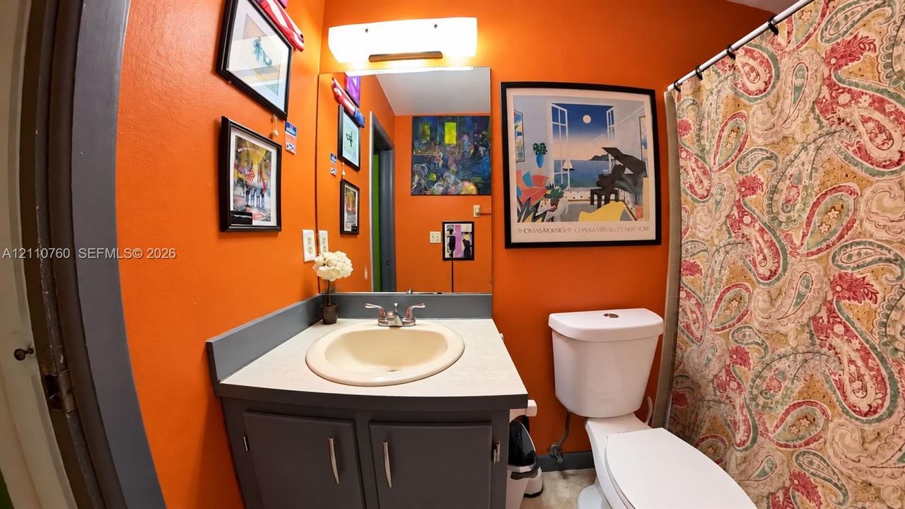 Bathroom featuring a gray vanity cabinet, integrated sink, countertop, and an above-mirror light fixture