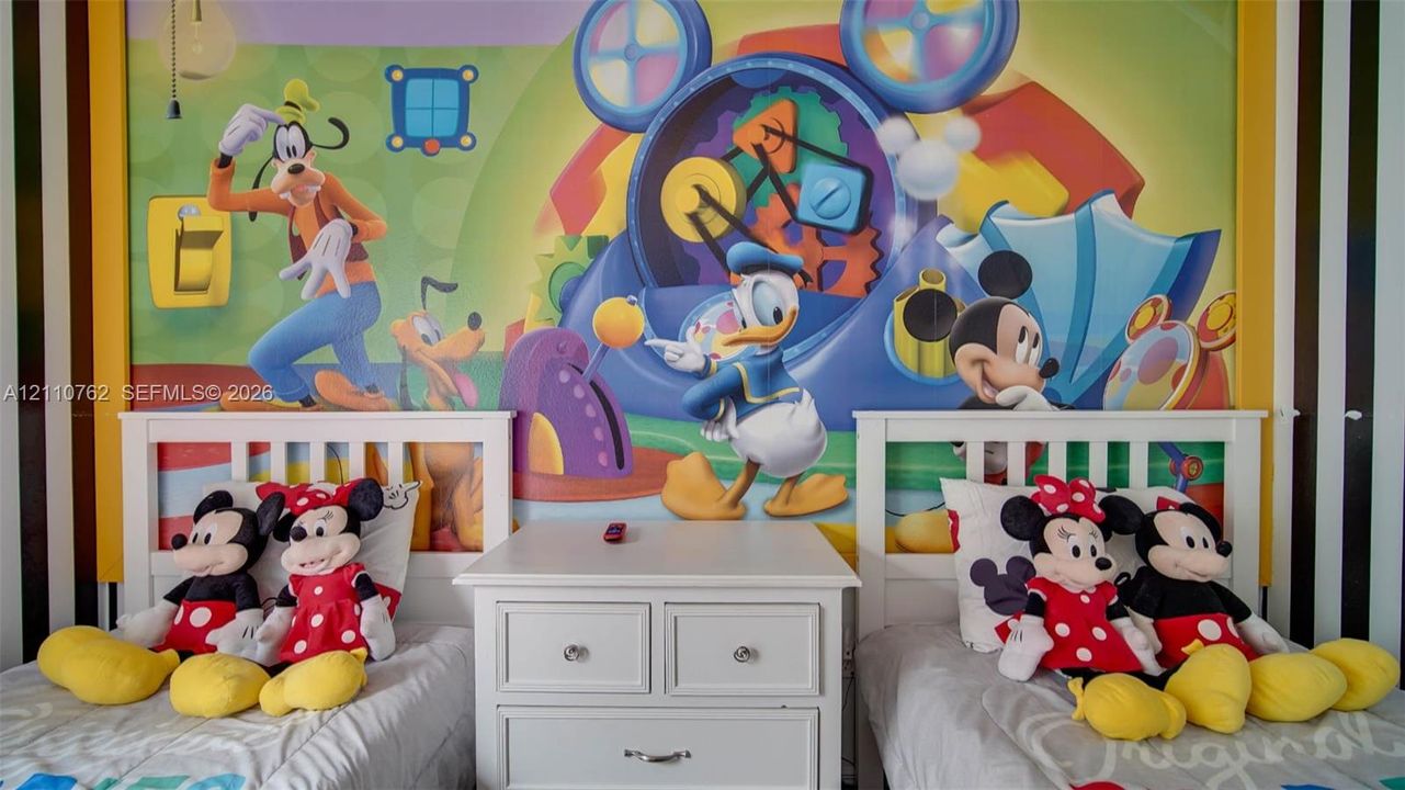 Wall-to-wall decorative graphic mural featuring a vibrant color palette, framed by vertical black and white striped accents