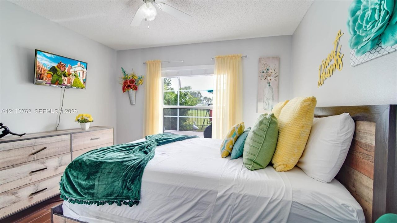 Neutral wall color, ceiling fan with light fixture, and sliding glass door with exterior screen