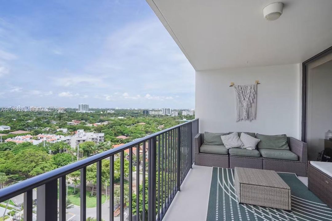 Covered balcony featuring metal railings and a concrete floor