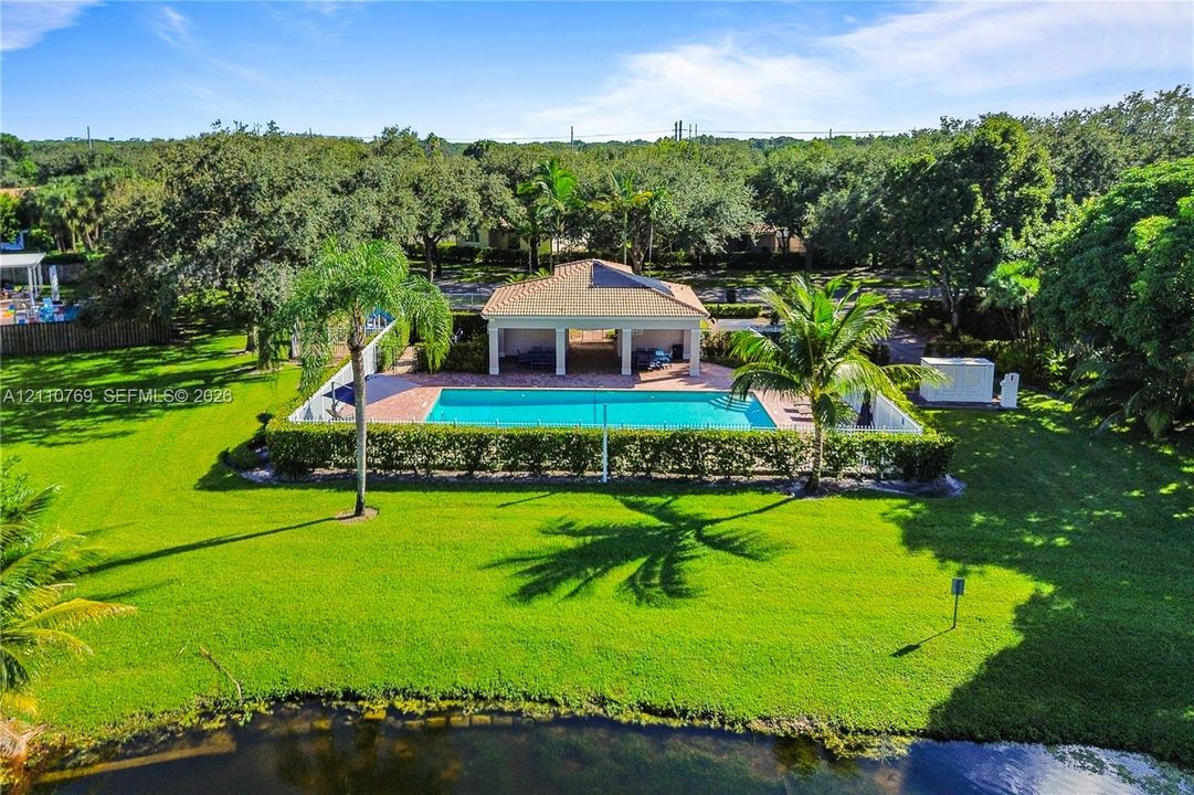 Expansive lawn featuring a swimming pool, covered pavilion, hardscaped patio, and waterfront perimeter