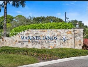 Stone-clad monument entrance featuring engraved lettering, decorative compass rose inlay, and professional landscaping