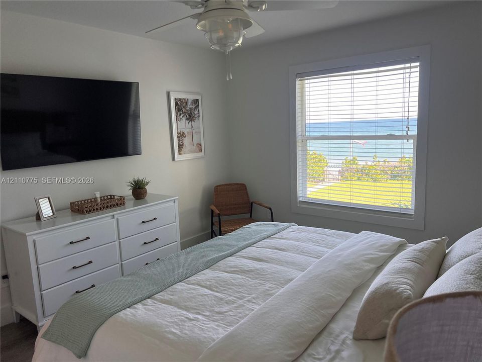 Room featuring neutral wall paint, ceiling fan with integrated lighting, and a double-hung window with horizontal blinds