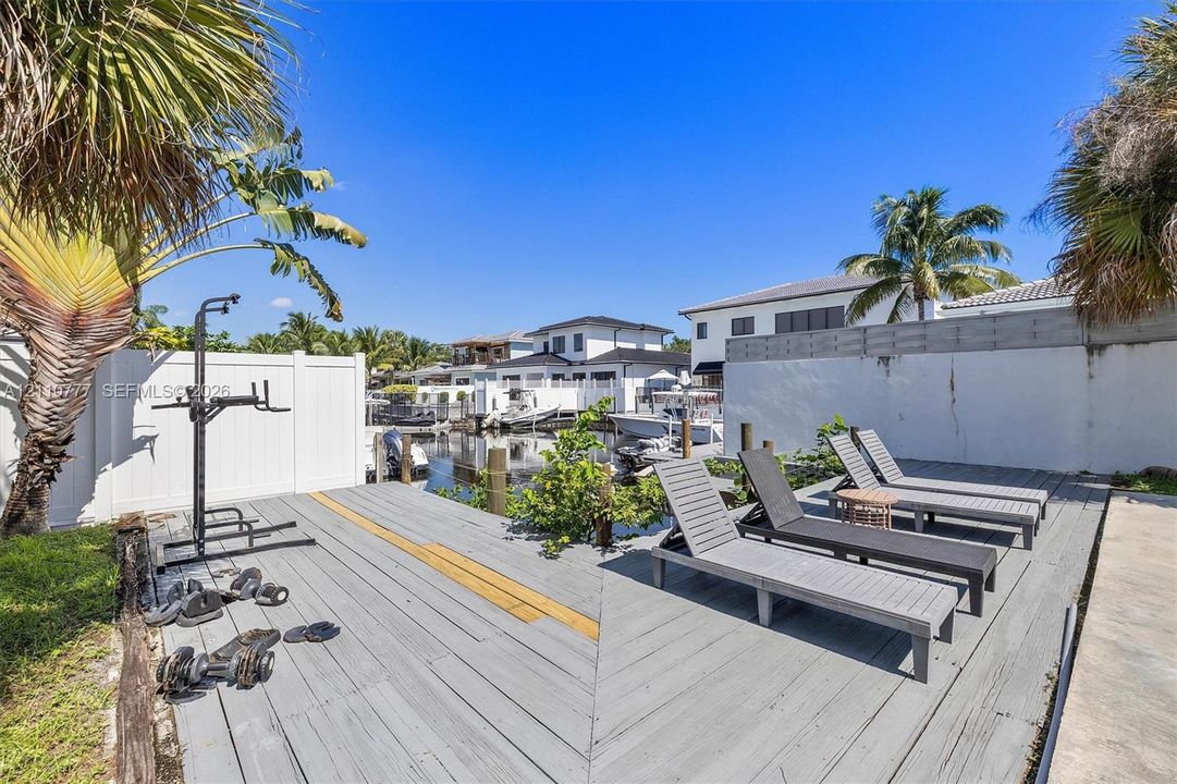 Waterfront deck featuring durable composite decking, wooden pilings, privacy fencing, and direct water access