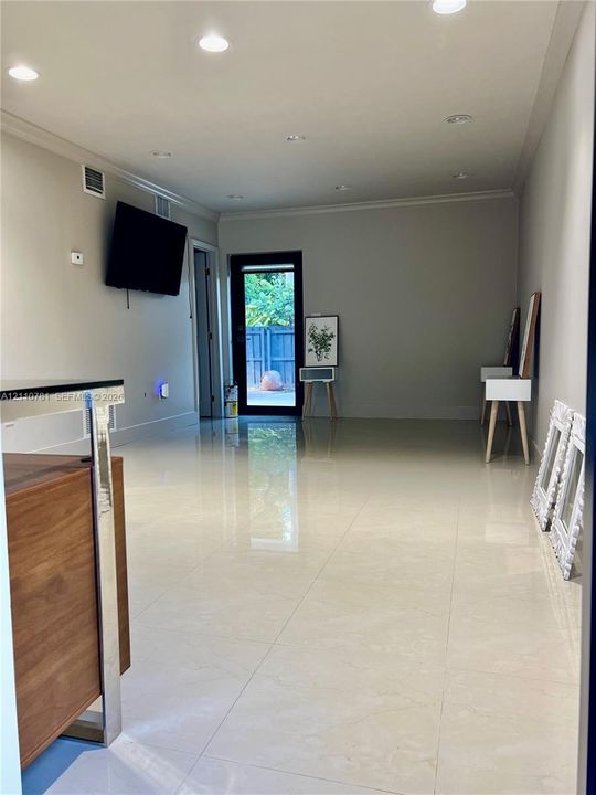 Interior space featuring high-gloss tile flooring, recessed ceiling lighting, and a glass-paneled exterior door