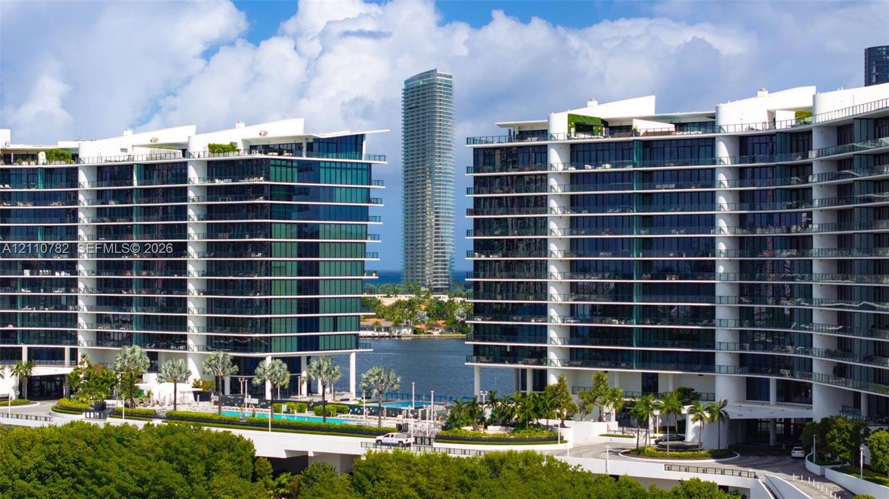 Modern high-rise architecture featuring expansive glass curtain walls, wrap-around balconies, deep-water access, and integrated ground-level swimming pools