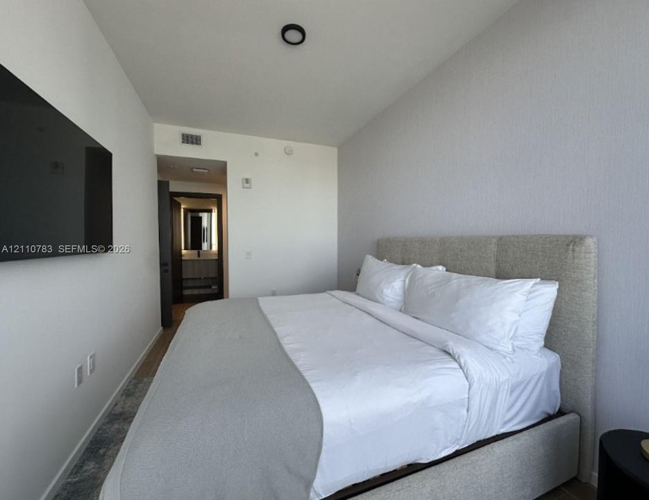 Neutral-toned interior featuring textured wall finishes, recessed ceiling lighting, and smooth-finish flooring