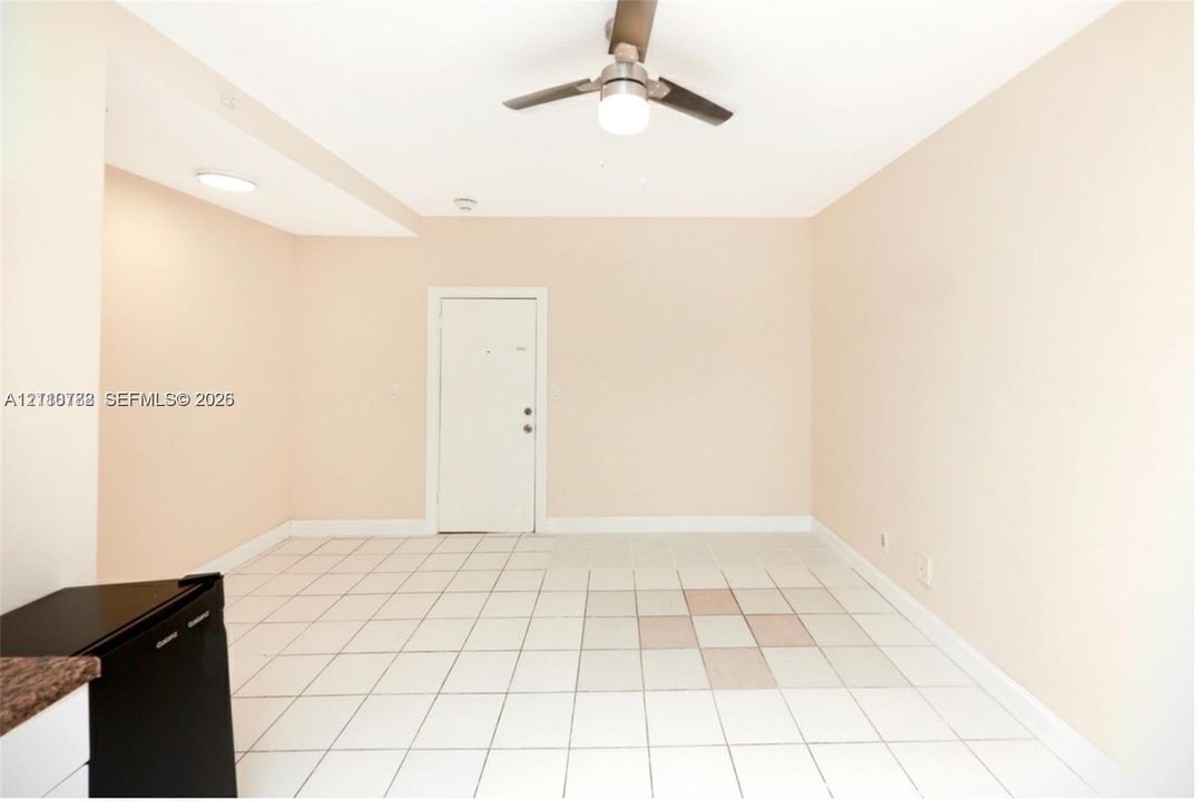 Neutral-toned interior featuring ceramic tile flooring, a central ceiling fan with an integrated light fixture, and recessed overhead lighting