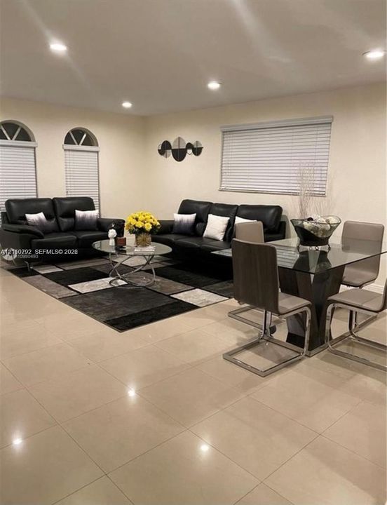 Polished tile flooring, recessed lighting, and arched windows with horizontal blinds