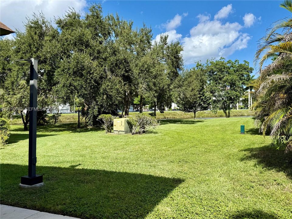 Expansive grass lawn featuring mature trees and a dedicated post lamp