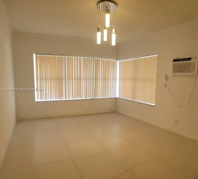 Interior space featuring large-format ceramic tile flooring, vertical window blinds, and a multi-light contemporary ceiling fixture