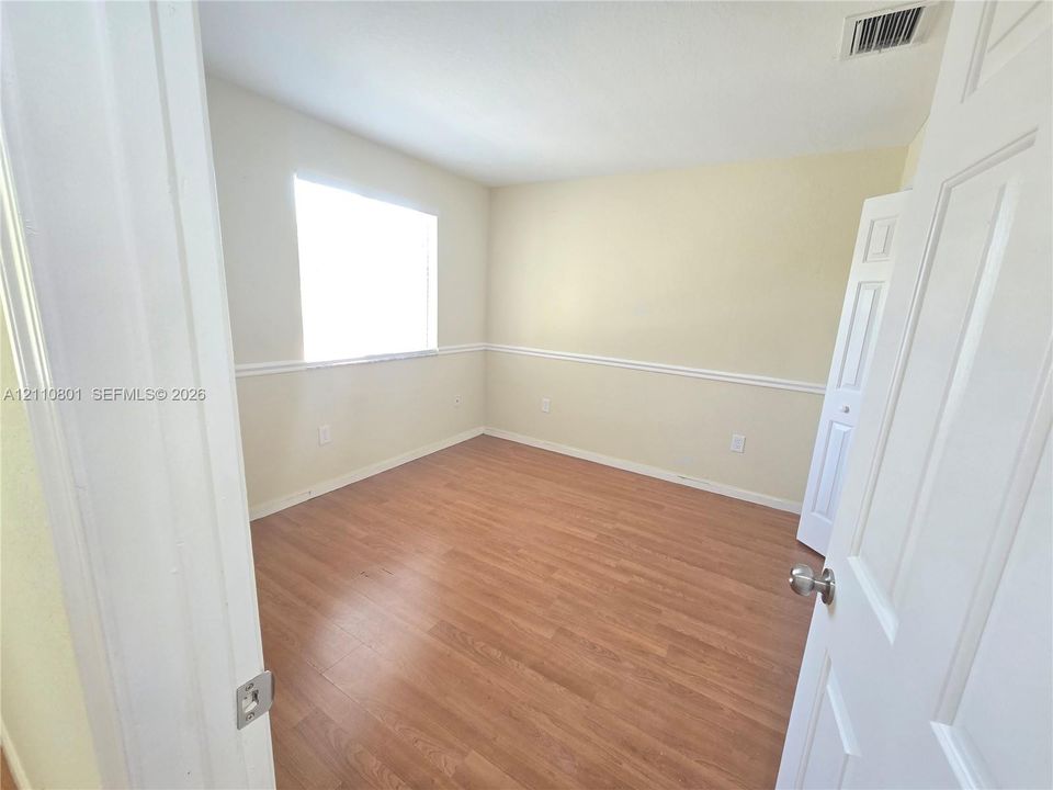 Interior room featuring wood-finish flooring, chair rail molding, and a paneled door